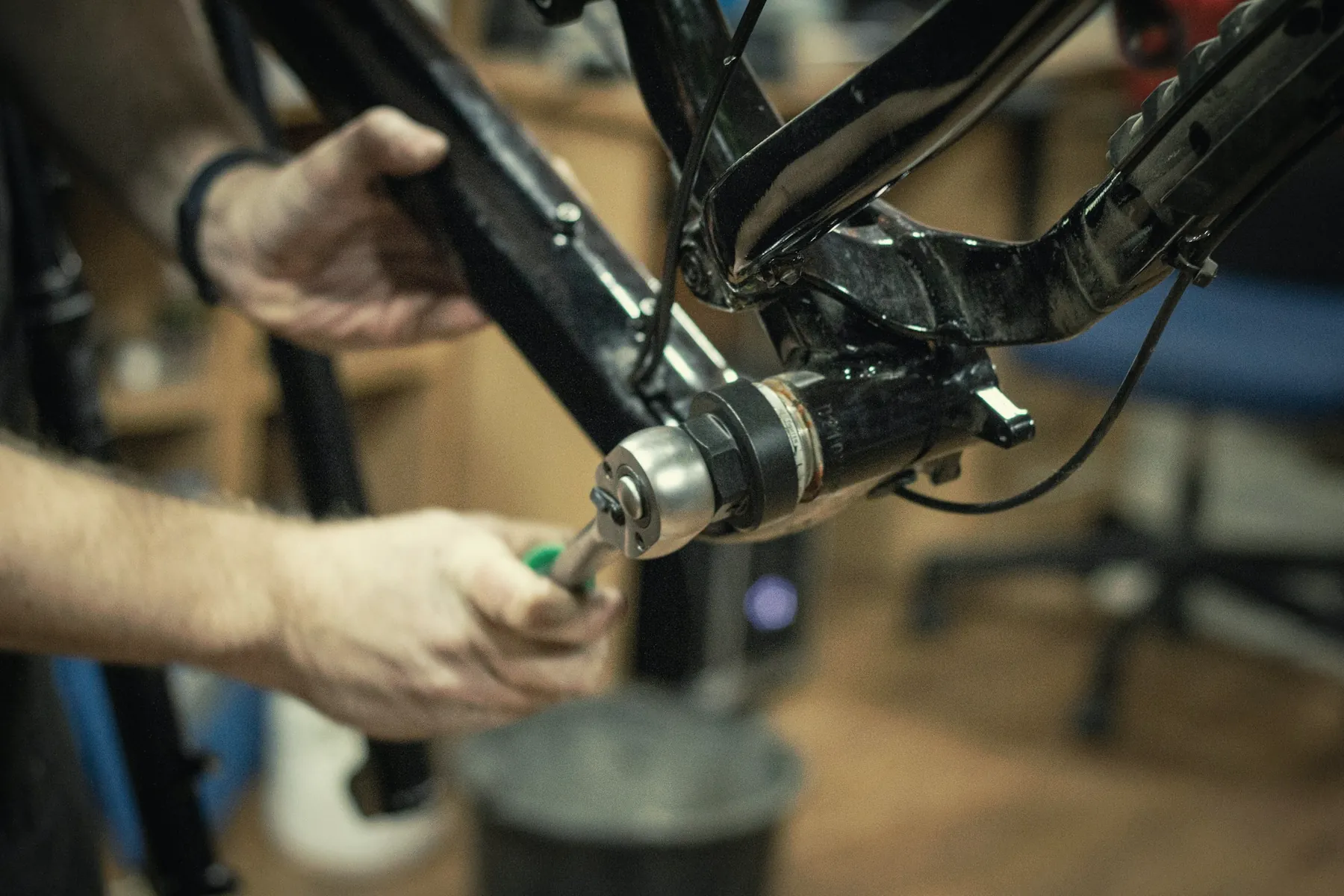 Mani che lavorano sul movimento centrale di una bici